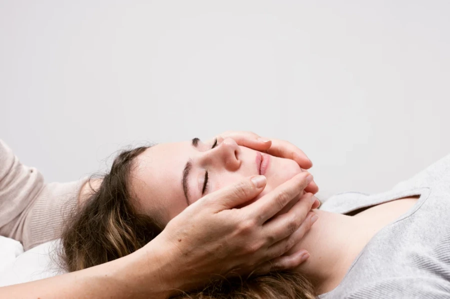 Craniosacraltherapeutin behandelt Klienten sanft am Kopf