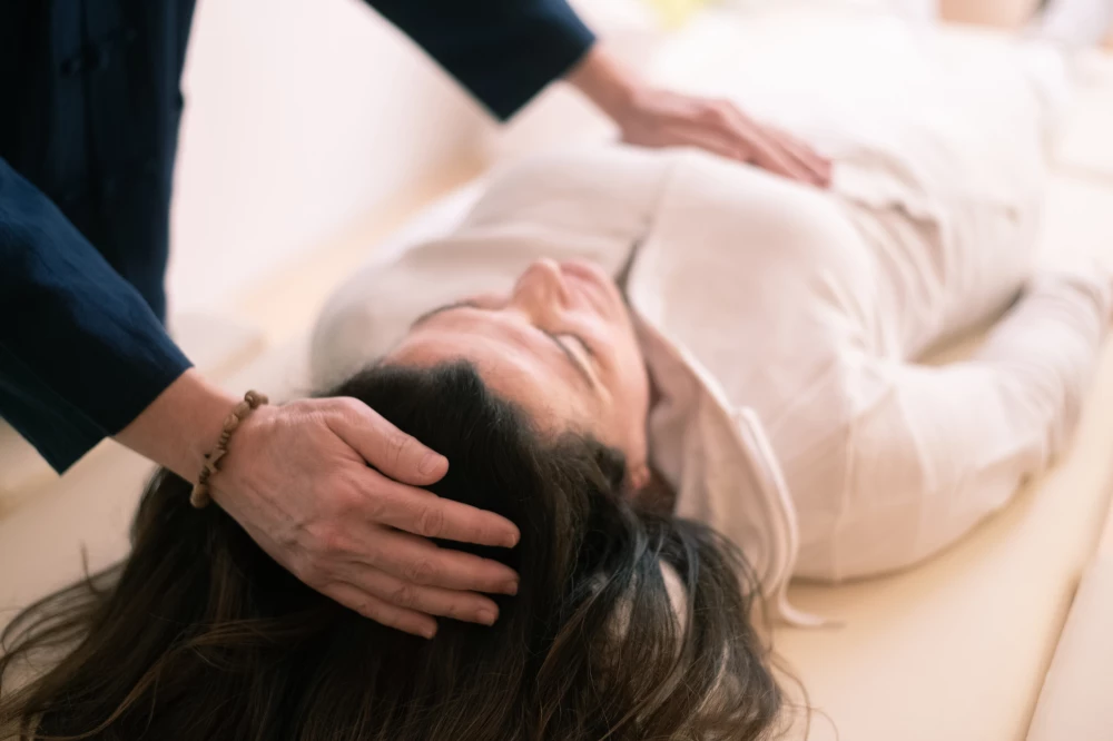 Craniosacraltherapeutin behandelt Klienten sanft am Kopf